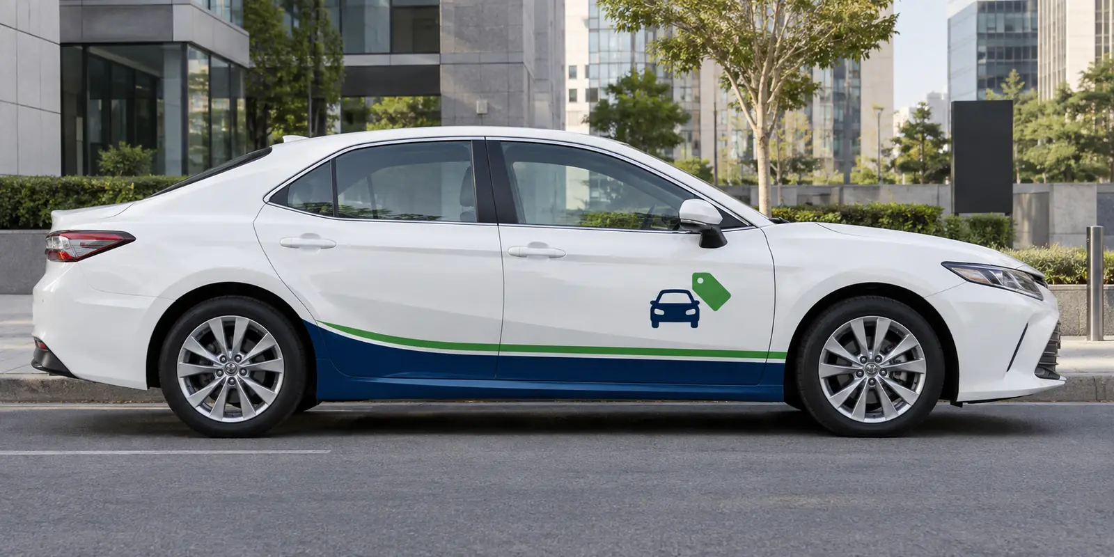 White Toyota Camry with Budget Cruze navy and green livery on a city street
